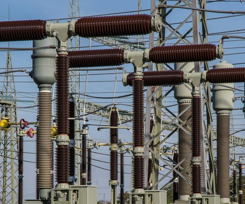 Detailed view of high voltage electrical substation with transformers and power lines.