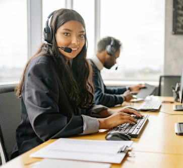 A Smiling Woman Working in a Call Center while Looking at Camera