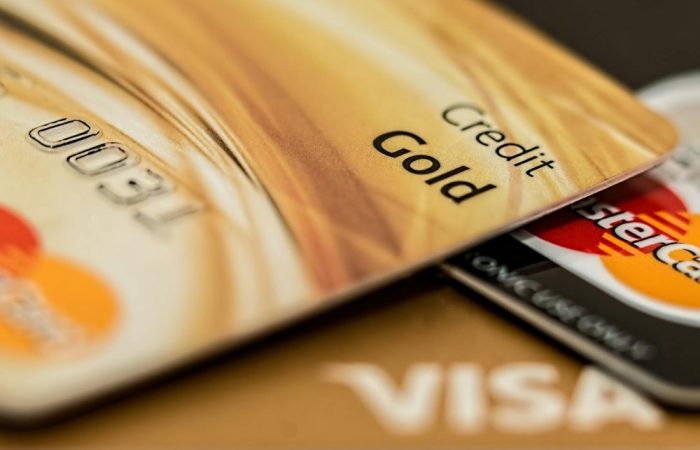 Stack of various branded credit cards focusing on gold card showing finance and cashless concept.