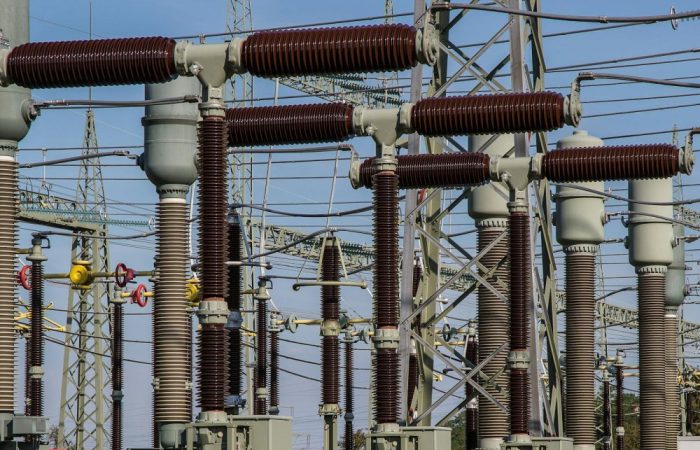 Detailed view of high voltage electrical substation with transformers and power lines.
