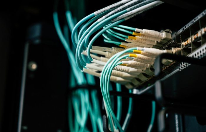 Detailed view of network cables plugged into a server rack in a data center.