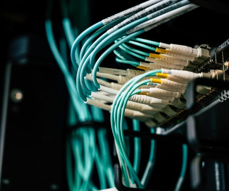 Detailed view of network cables plugged into a server rack in a data center.